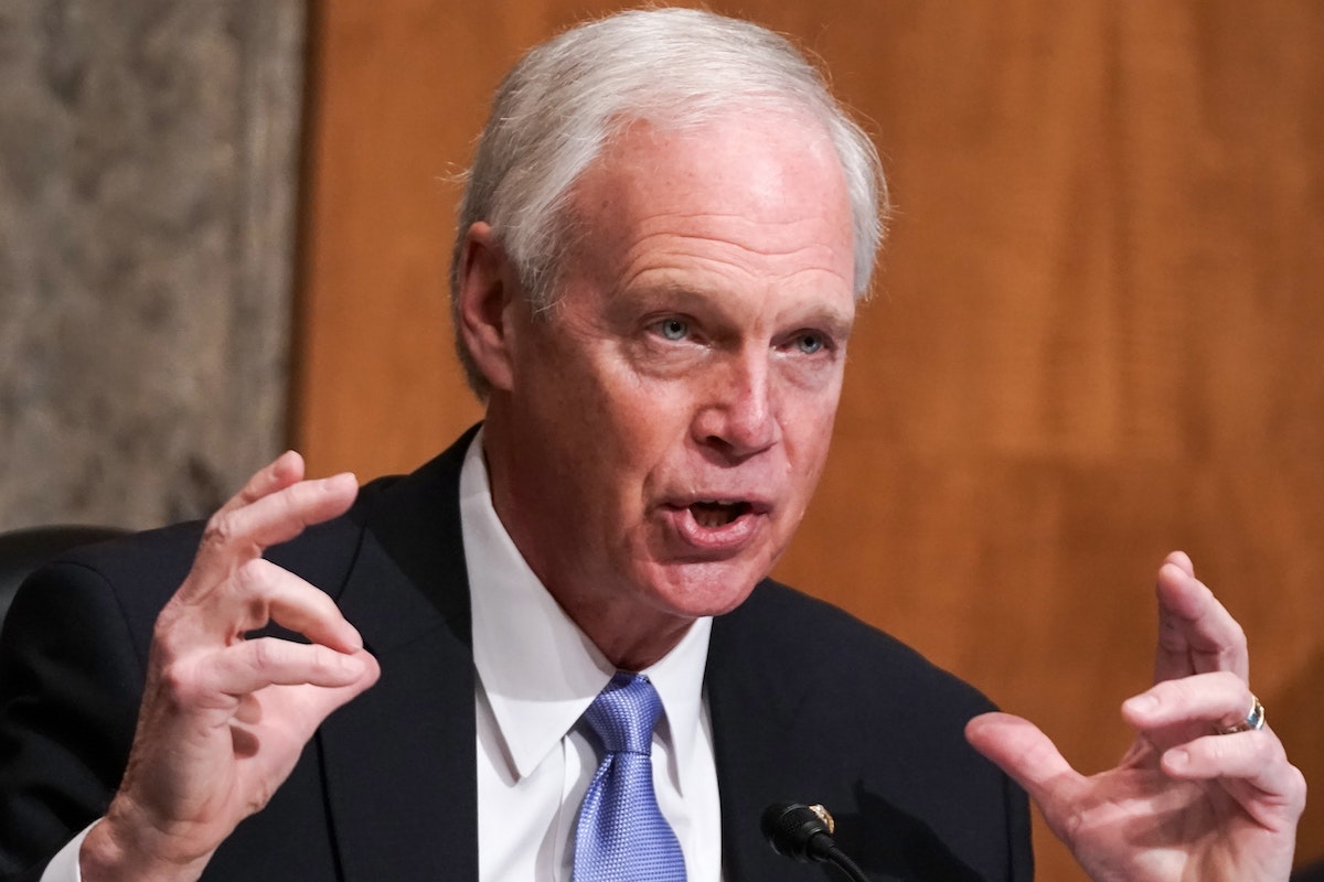 Ron Johnson holds up his hands during a Senate hearing